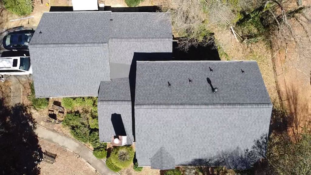 An aerial view of a house with a car parked in front of it