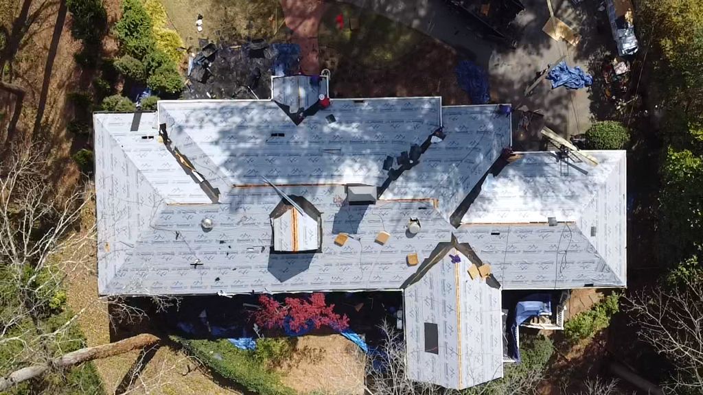 An aerial view of a house with a roof that is being installed.