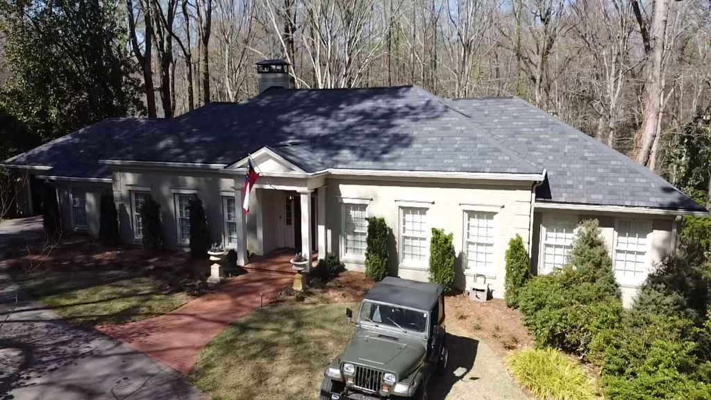 An aerial view of a house with a jeep parked in front of it.