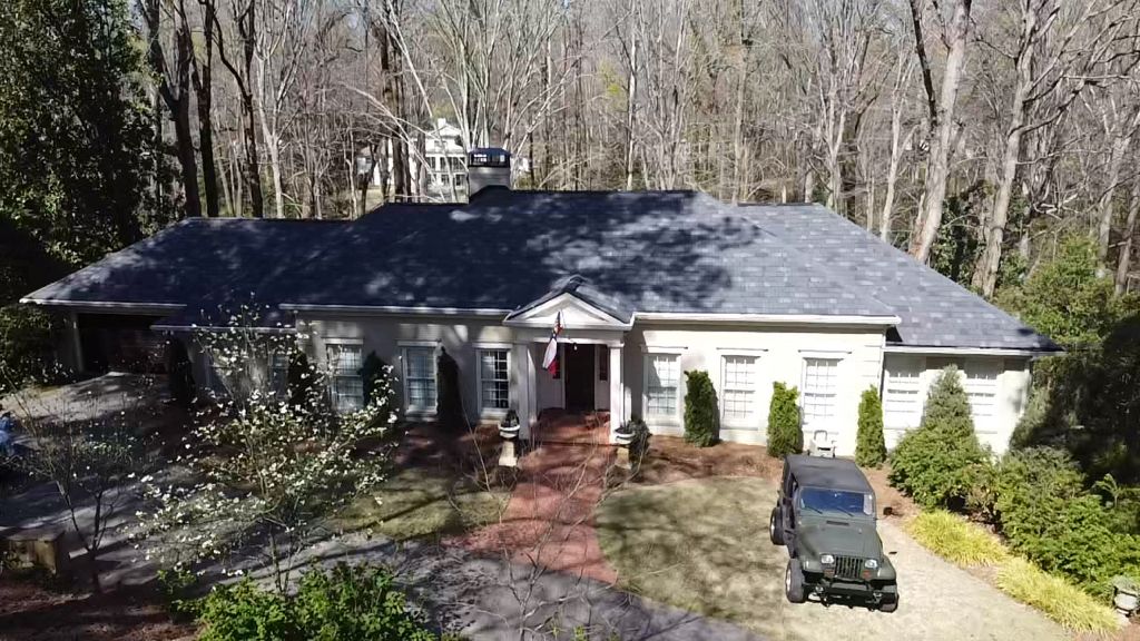An aerial view of a house with a jeep parked in front of it.