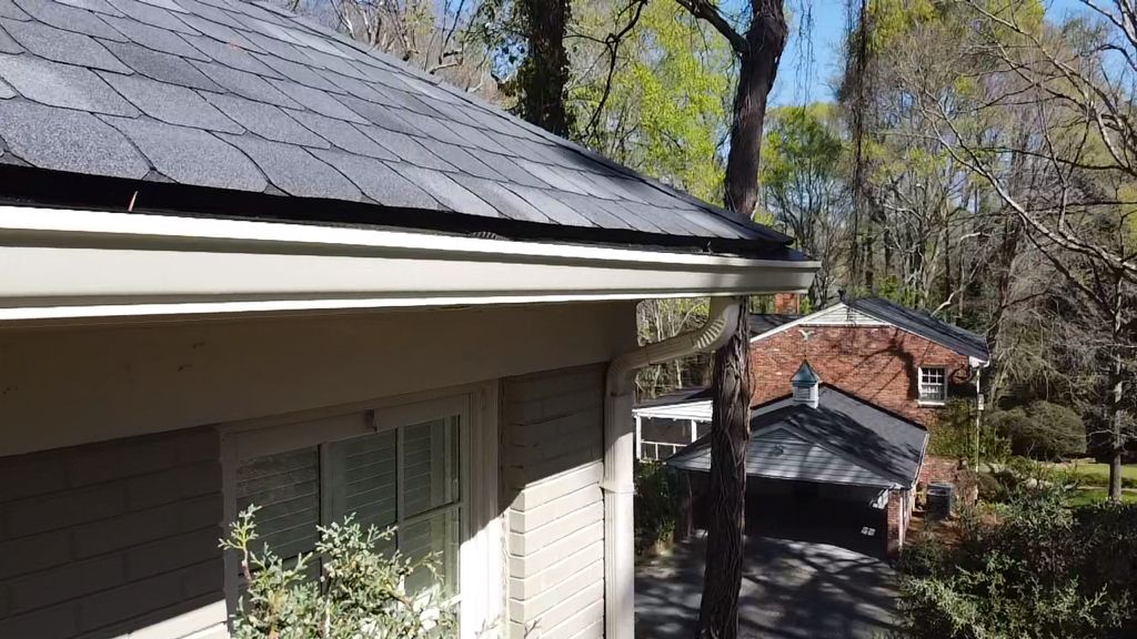 A house with a black roof and a white gutter.