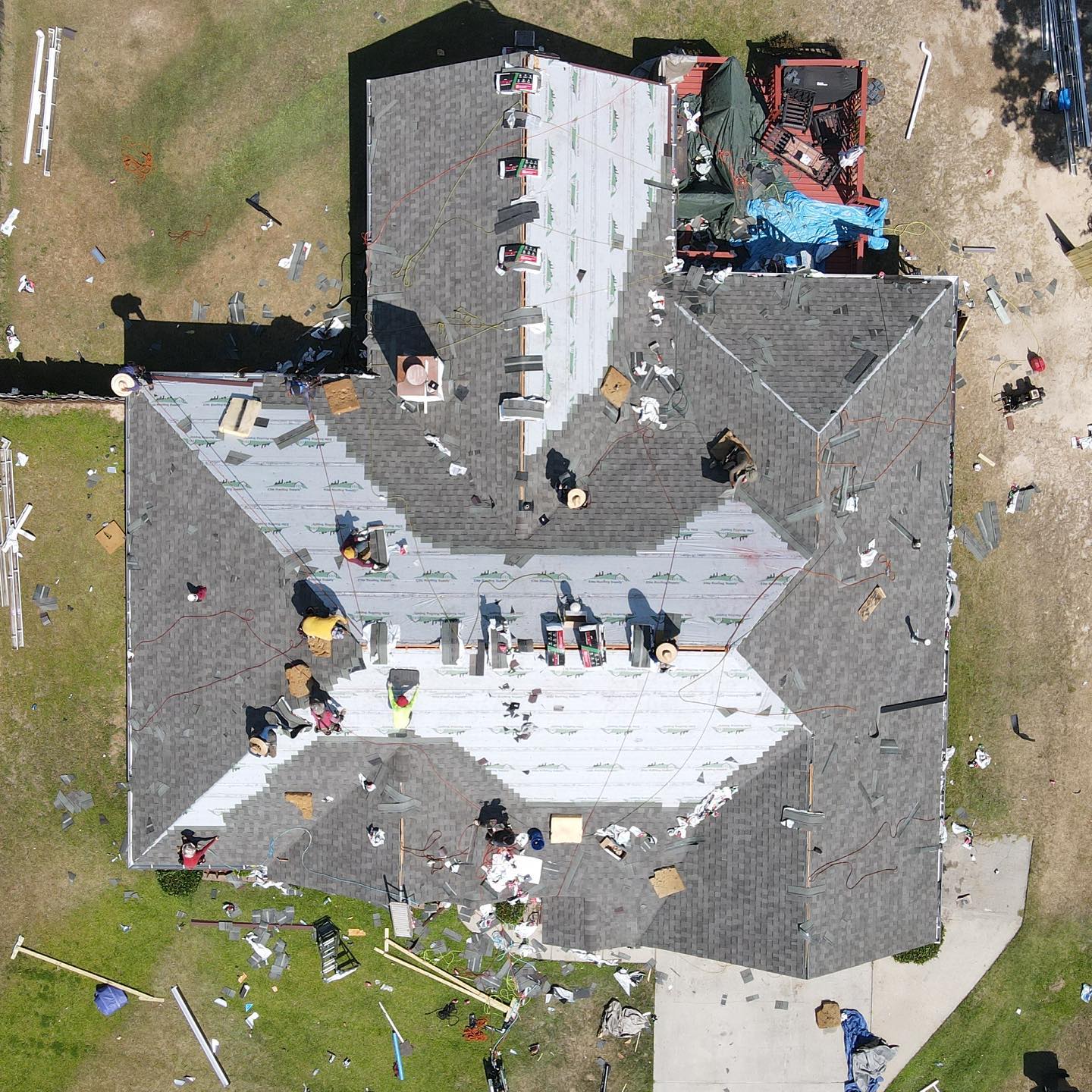 An aerial view of a house with a roof that is being repaired