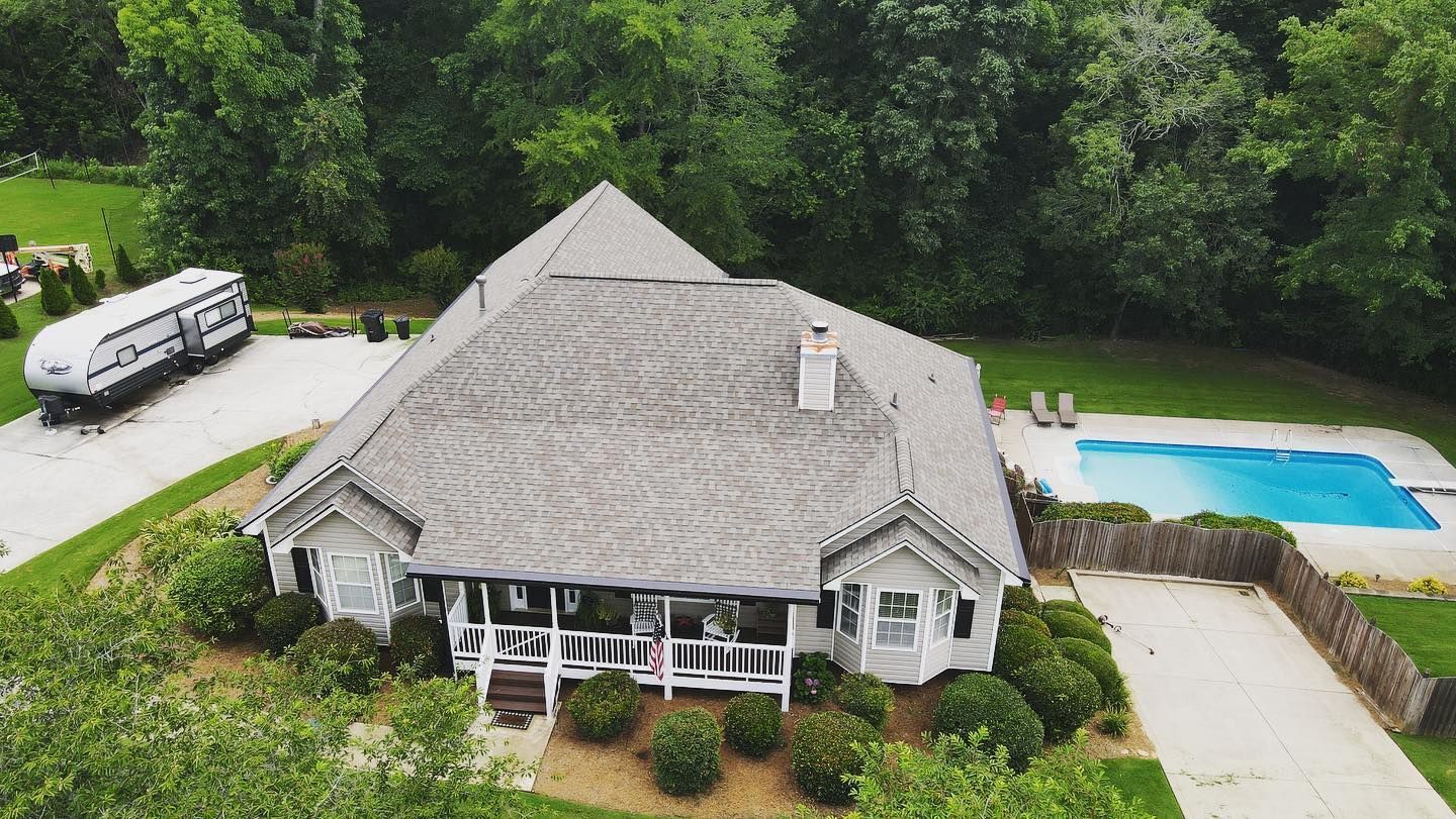 An aerial view of a large house with a pool in the backyard.