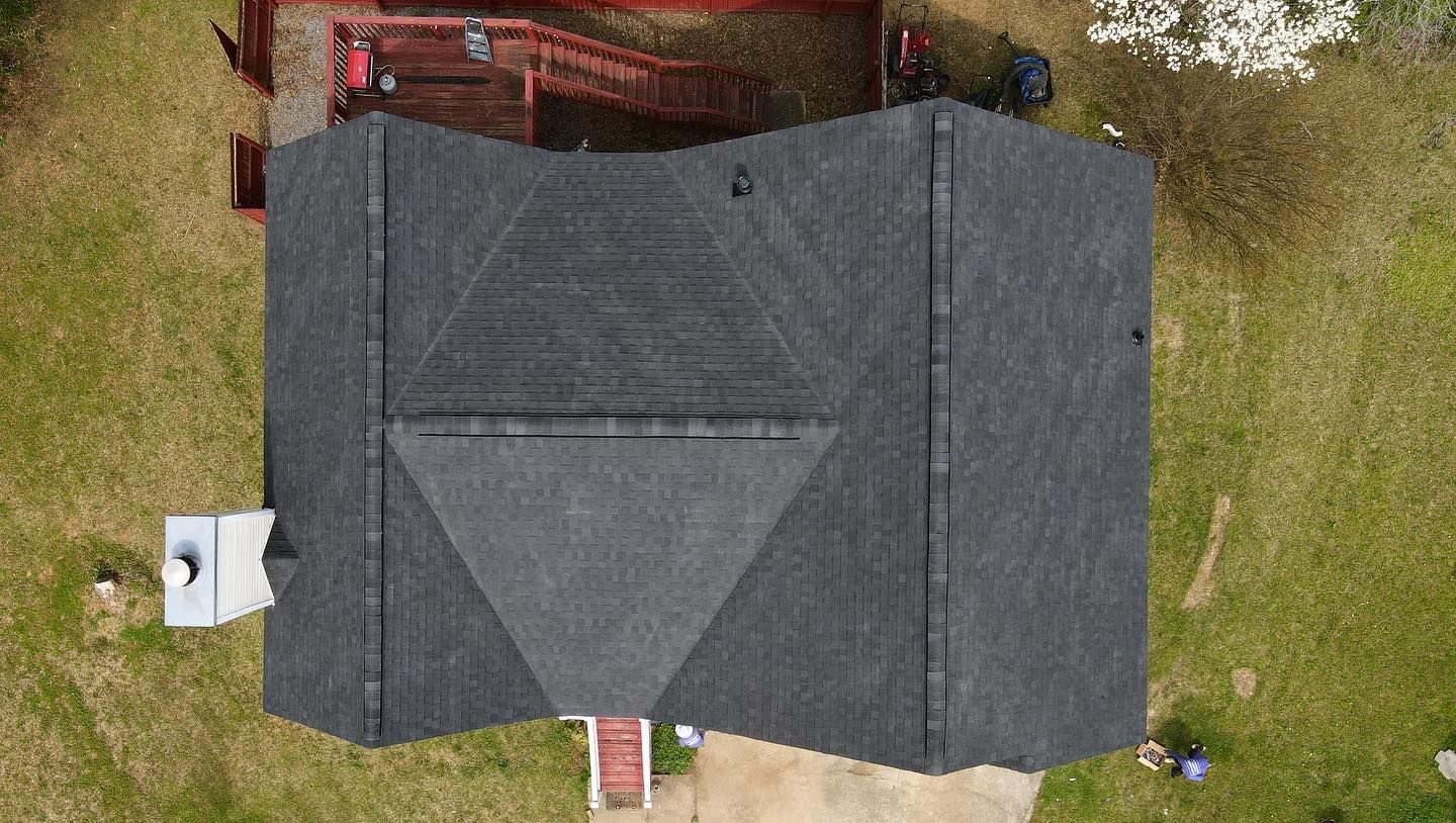 An aerial view of a house with a black roof.