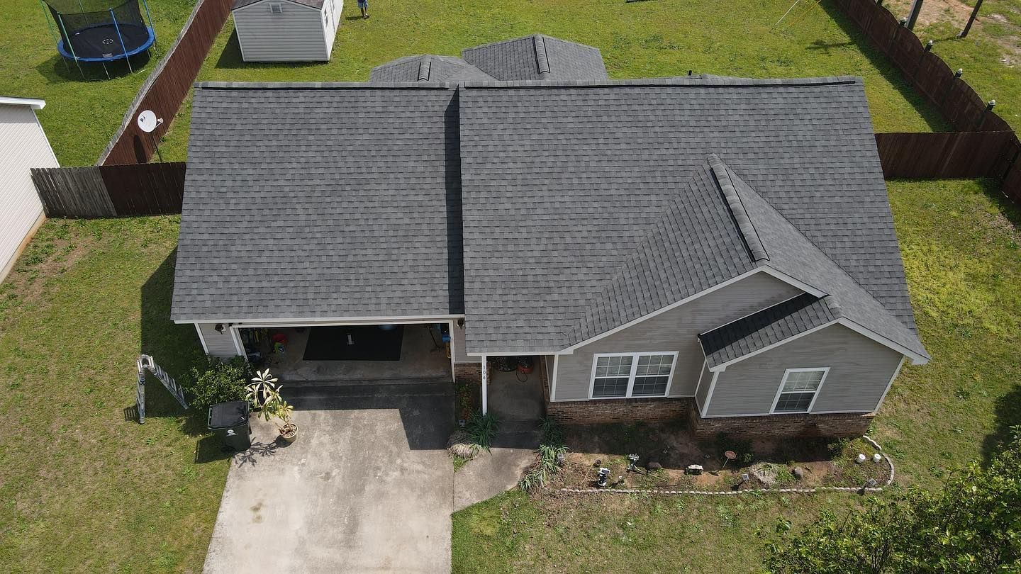 An aerial view of a house with a trampoline in the backyard.