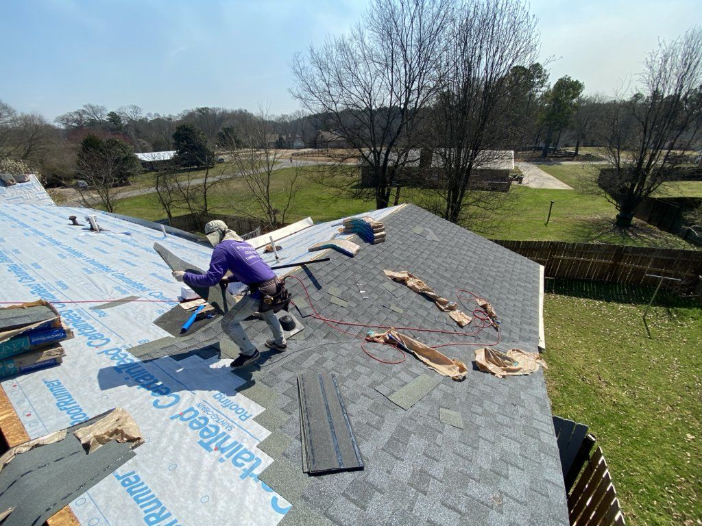 A man is working on the roof of a house.