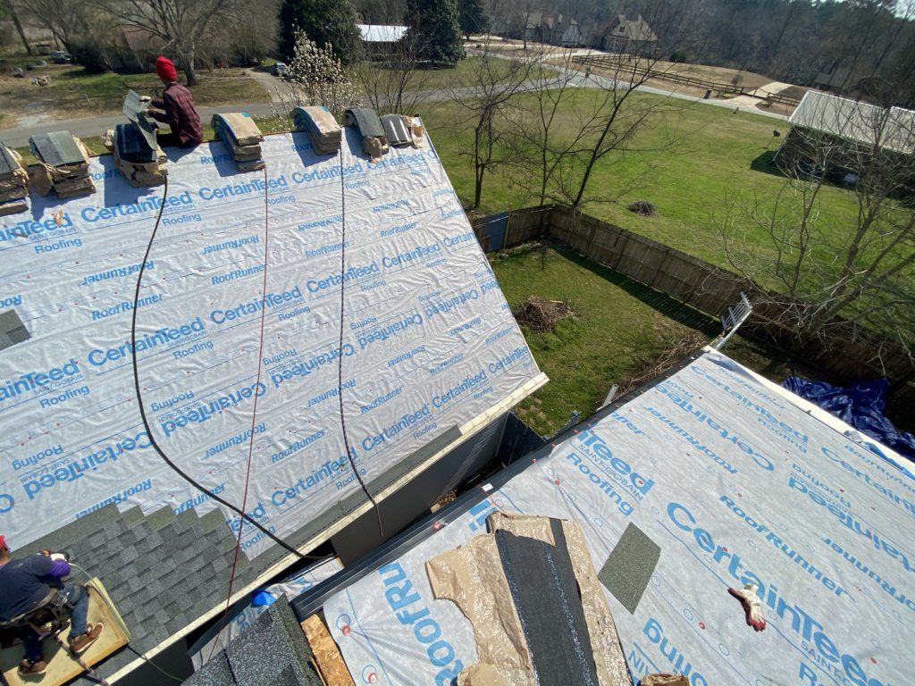 An aerial view of a roof being installed on a house.