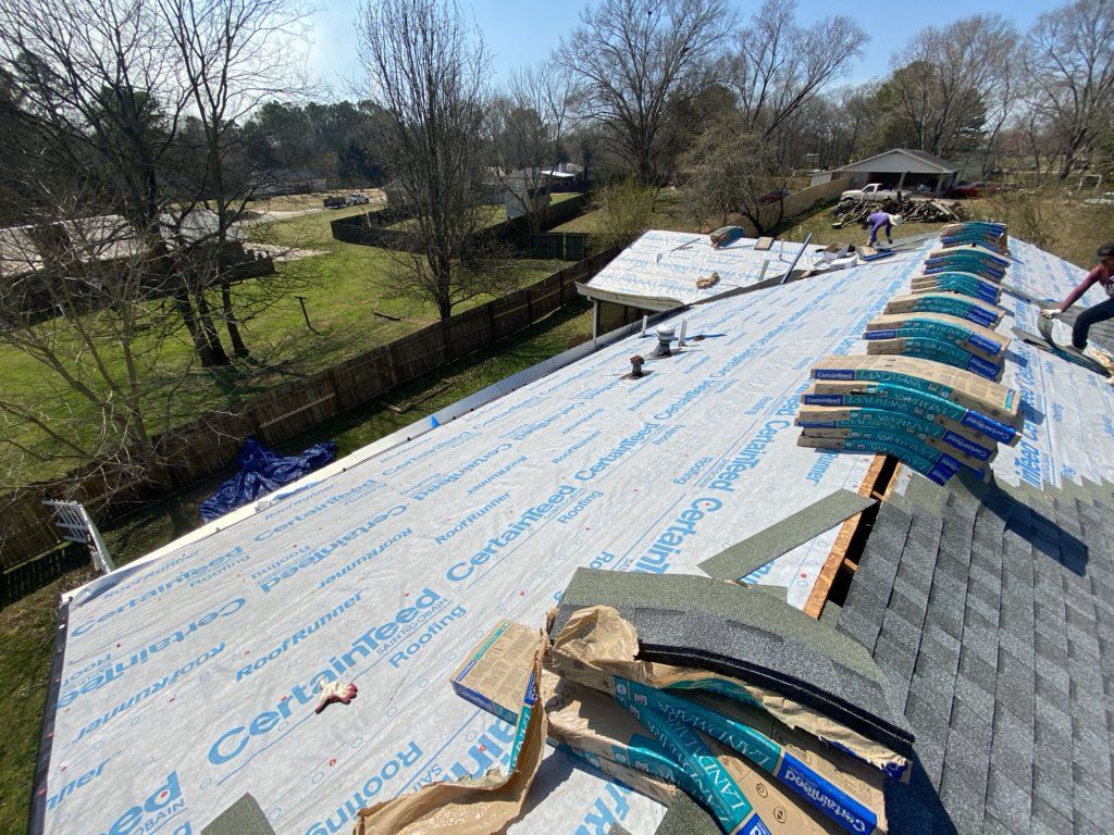A roof is being installed on a house with a lot of shingles on it.