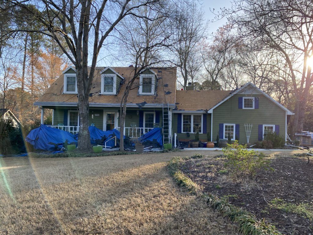 A large house with a roof that is being remodeled.
