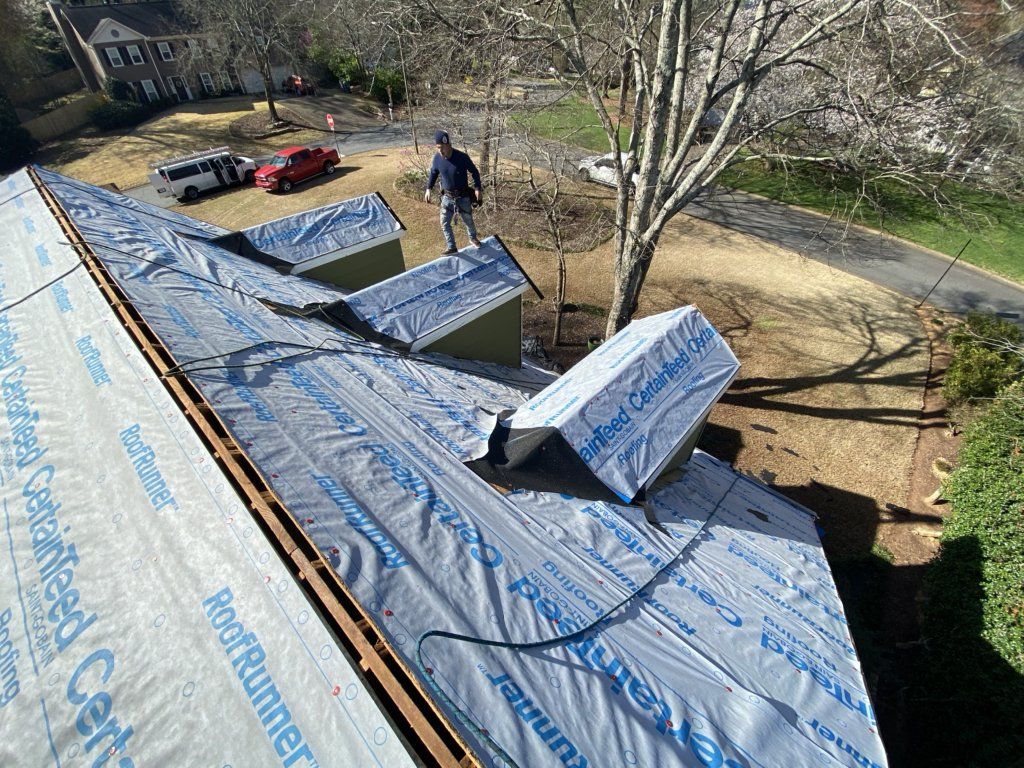 A man is working on the roof of a house.
