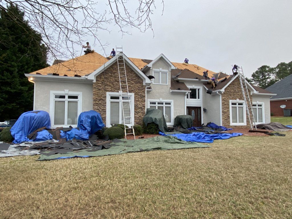 A large house is being remodeled with a roof being installed.
