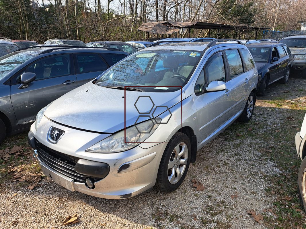 Un'auto argentata è parcheggiata in un parcheggio insieme ad altre auto.