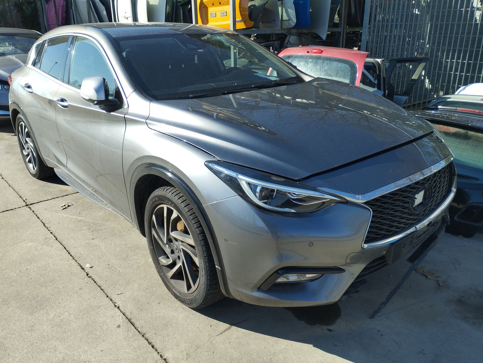 Un'auto grigia è parcheggiata sul ciglio della strada.