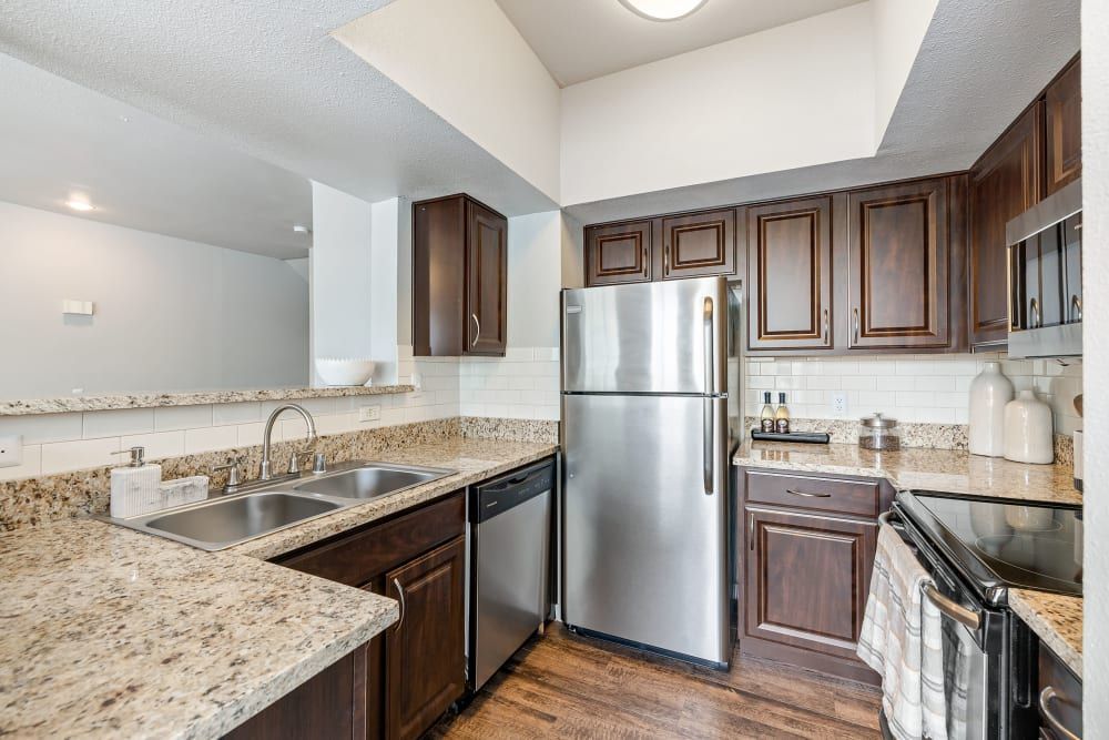 Apartment kitchen with stainless steel appliances and granite counter tops at Marquis at Stonegate offers apartments for rent in Fort Worth, TX.