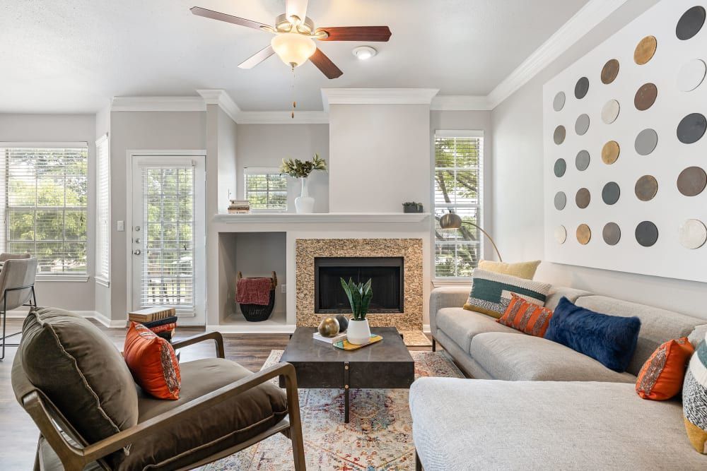 Apartment living room with a couch, chair, coffee table, and fireplace at Marquis at Stonegate offers apartments for rent with work-from-home space in Fort Worth, TX.