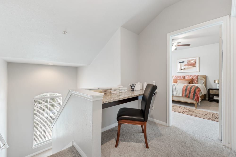 A desk and chair in the corner of the stairs as working area in our townhome floorplans at Marquis at Stonegate offers townhomes for rent with work-from-home space in Fort Worth, TX.