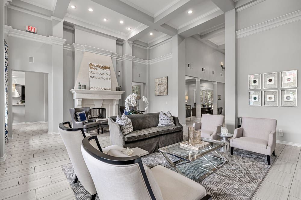 A clubhouse filled with furniture and a fireplace at Marquis at Stonegate offers apartments near Saginaw, TX.