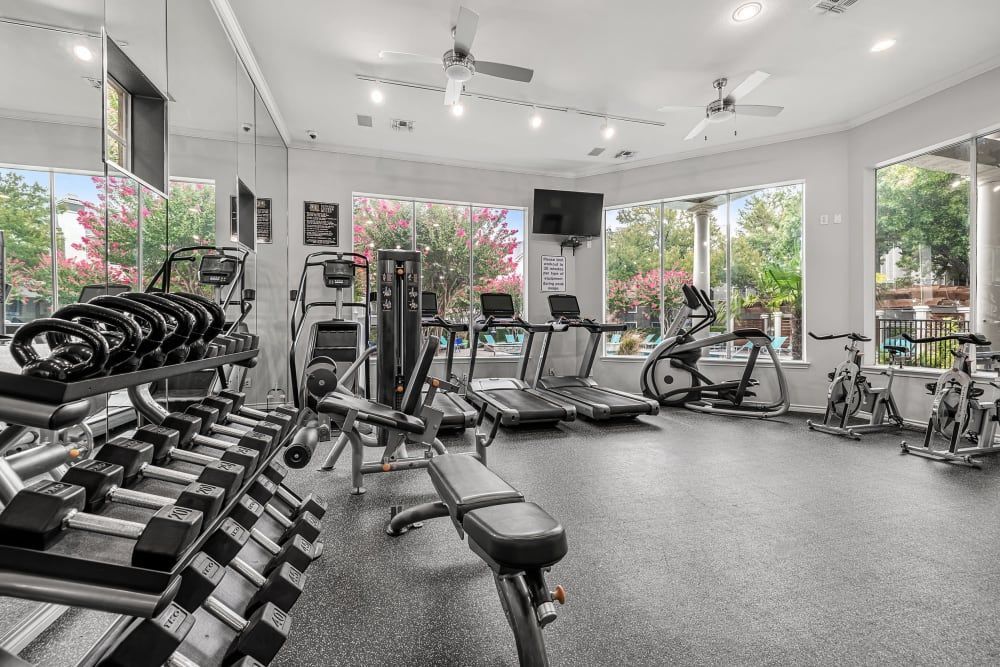 Marquis at Stonegate apartment community in Fort Worth offers a fitness center with a lot of dumbbells and treadmills.