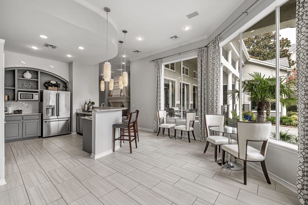 Clubhouse with kitchen and a lot of windows and seating area at Marquis at Stonegate offers apartments near Benbrook, TX.