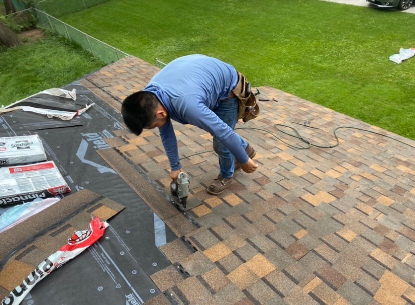 A man is working on a roof with a drill.