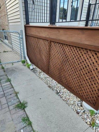 A wooden fence is sitting on the sidewalk next to a house.
