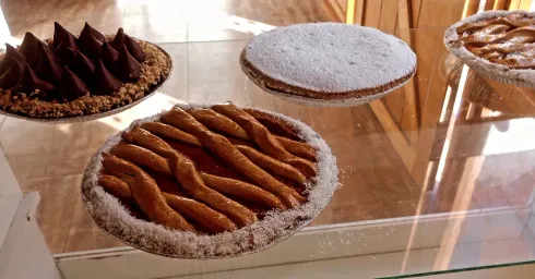 Pasteles en bandejas de cristal, incluyendo dulces espolvoreados con azúcar.