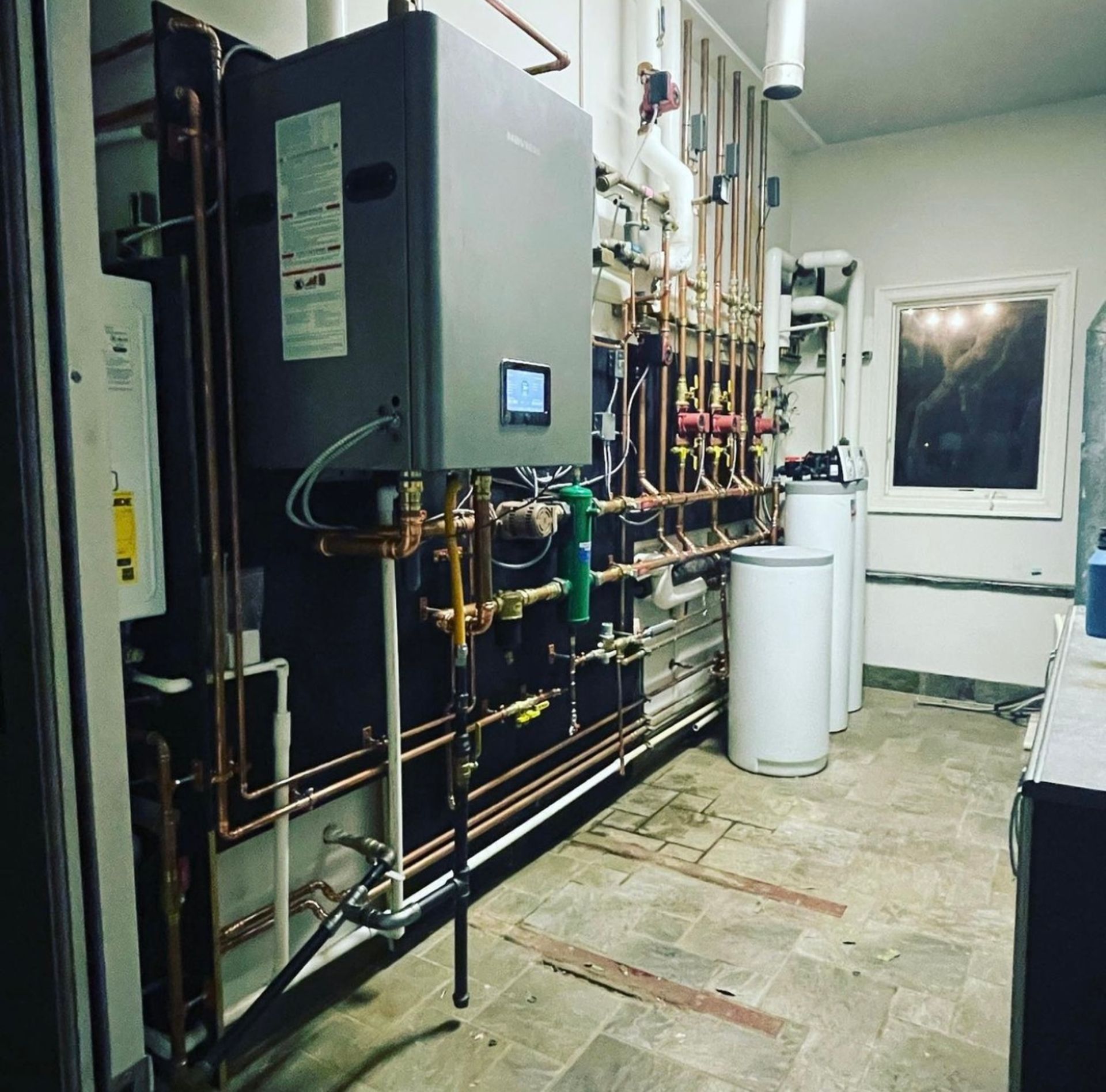 A room with a lot of pipes and a heater