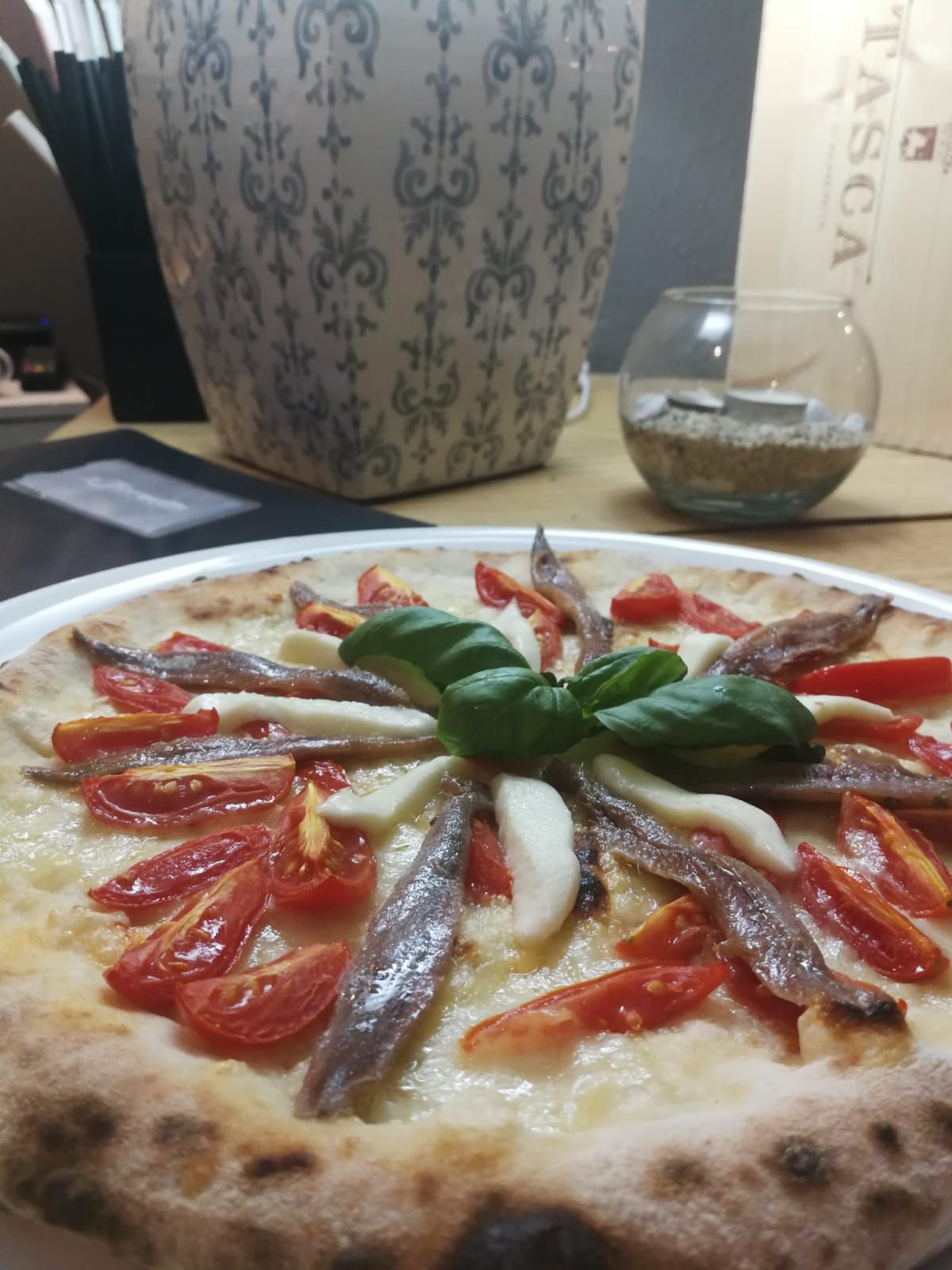 Una pizza con pomodori e basilico su un piatto
