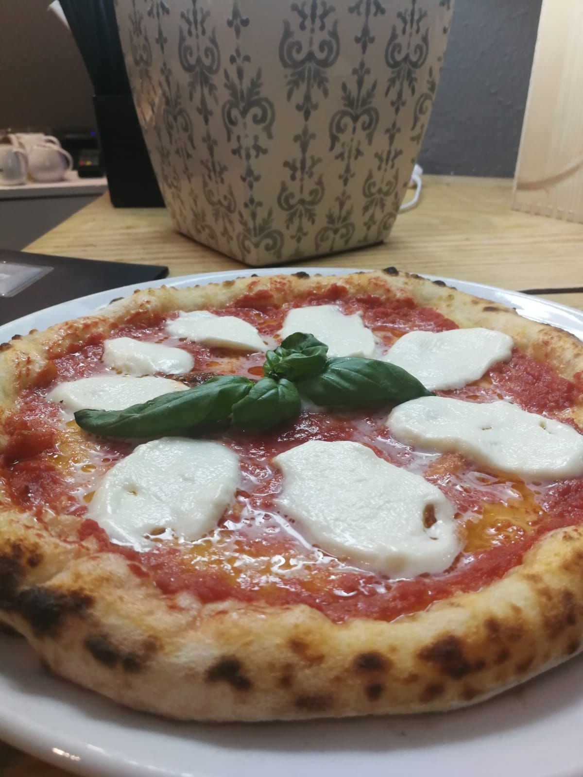 Una pizza con mozzarella e basilico su un piatto bianco