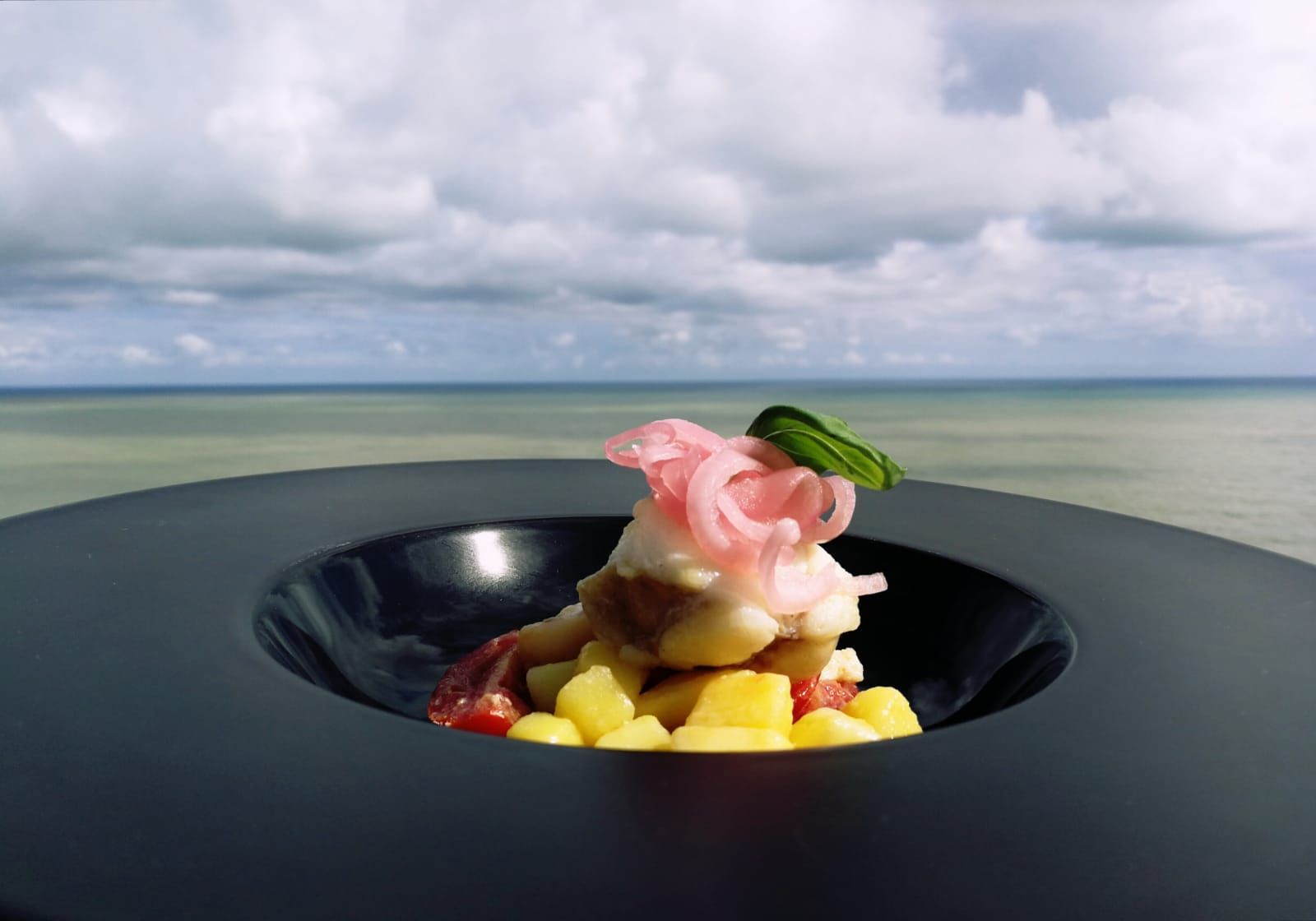 Un primo piano di un piatto di cibo con un fiore sopra