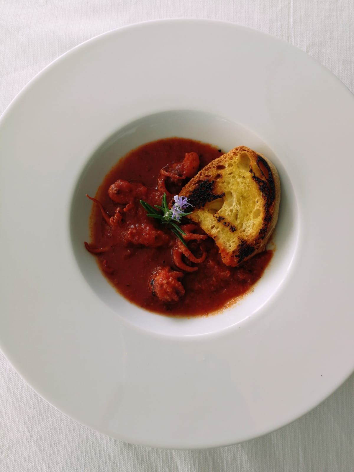 Un piatto bianco condito con salsa e pane