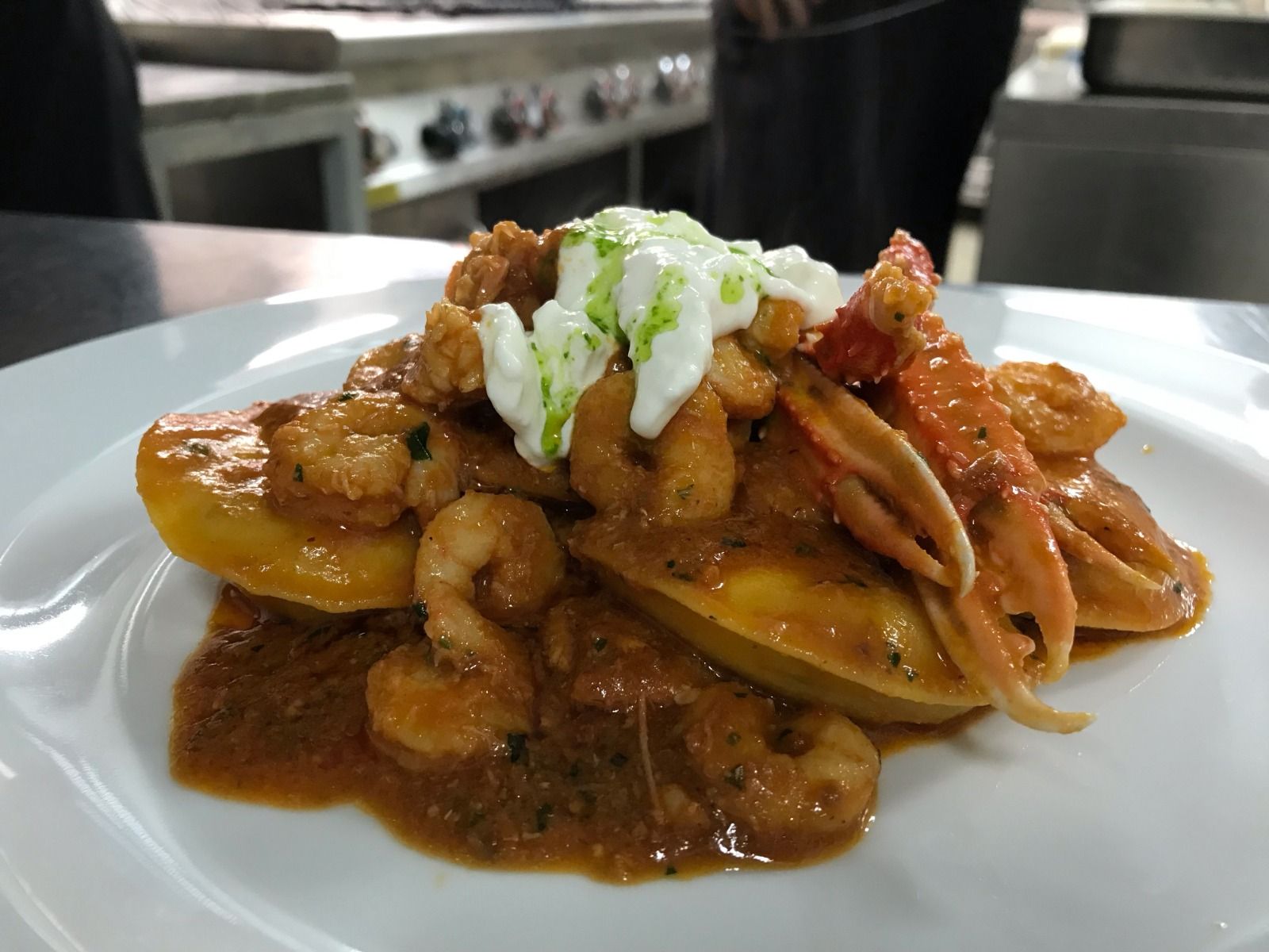 Un piatto bianco condito con gamberi e salsa