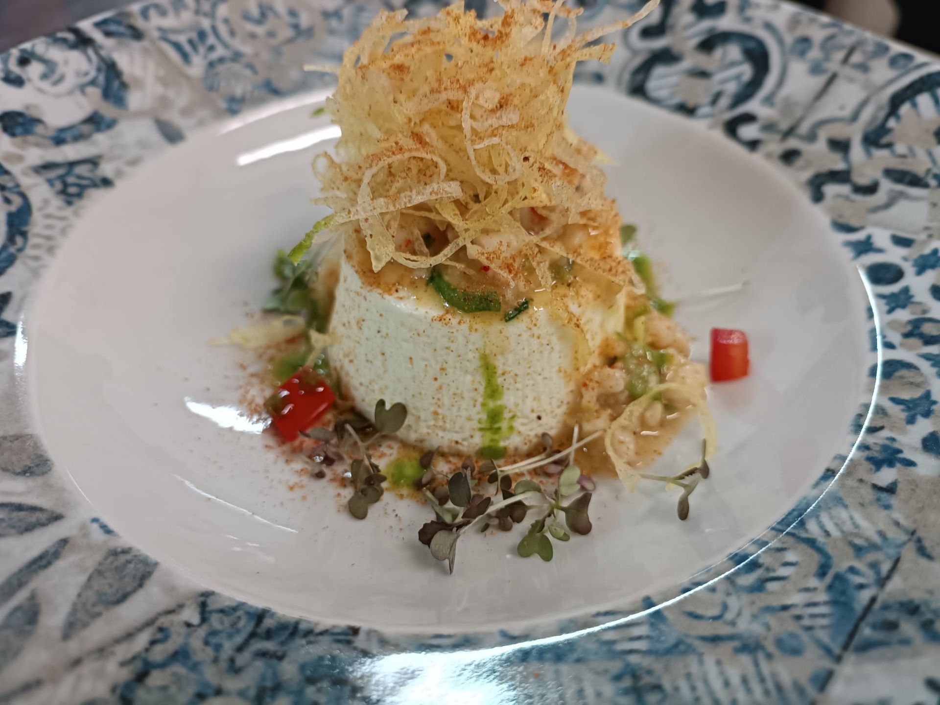 Un piatto bianco con sopra un dessert e delle verdure su un tavolo.