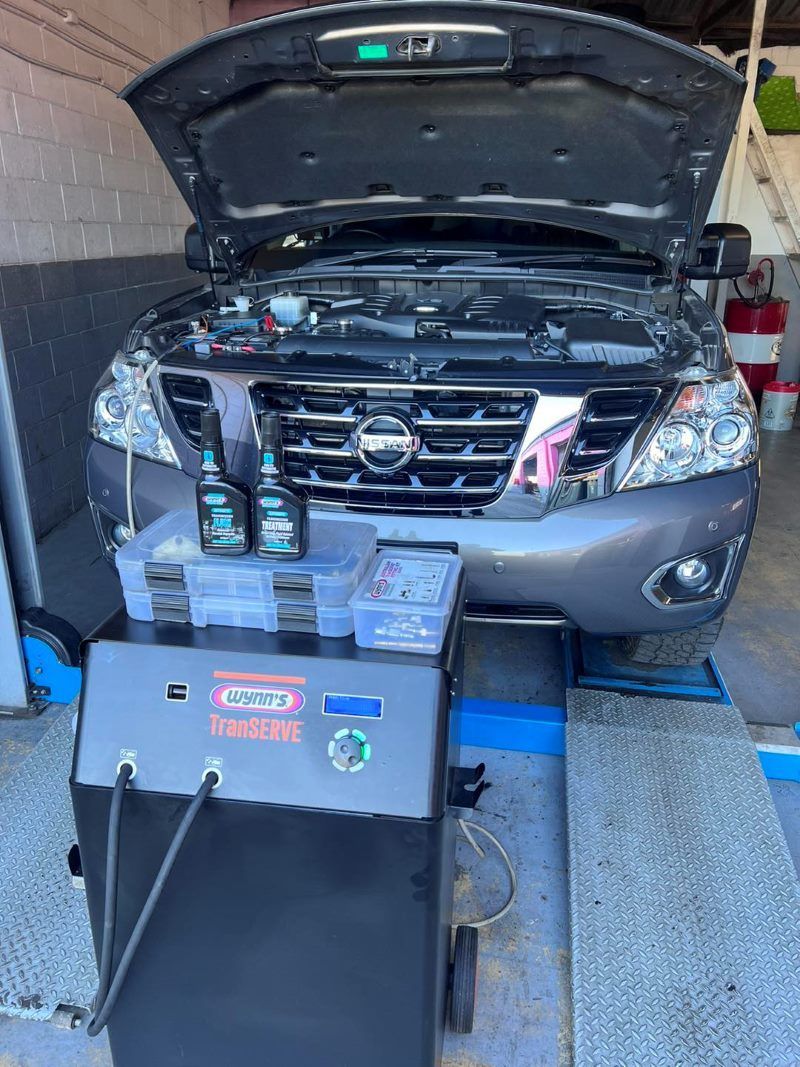 A Car With the Hood Up is Sitting in a Garage Next to a Machine — Rycam Automotive in Buderim, QLD