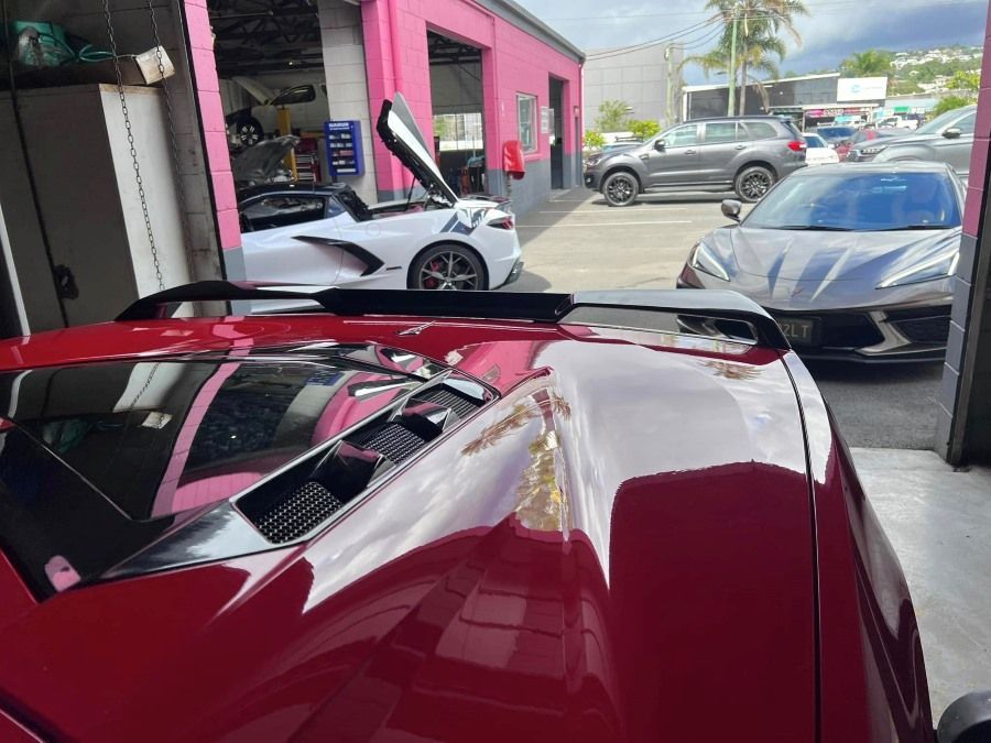 A Red Sports Car is Parked in Front of a Pink Building — Rycam Automotive in Buderim, QLD