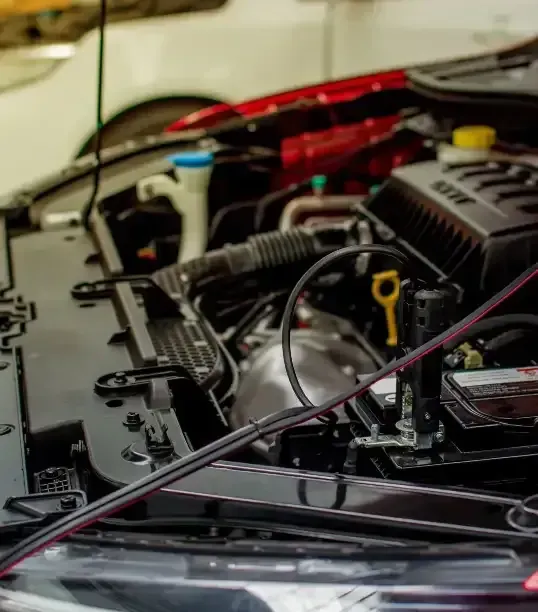 A close up of the engine of a car with the hood open.