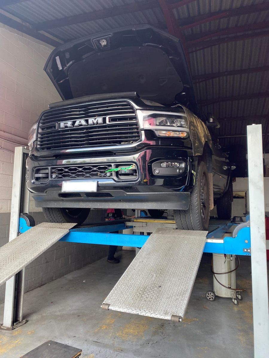 A Ram Truck is Sitting on a Lift in a Garage — Rycam Automotive in Buderim, QLD
