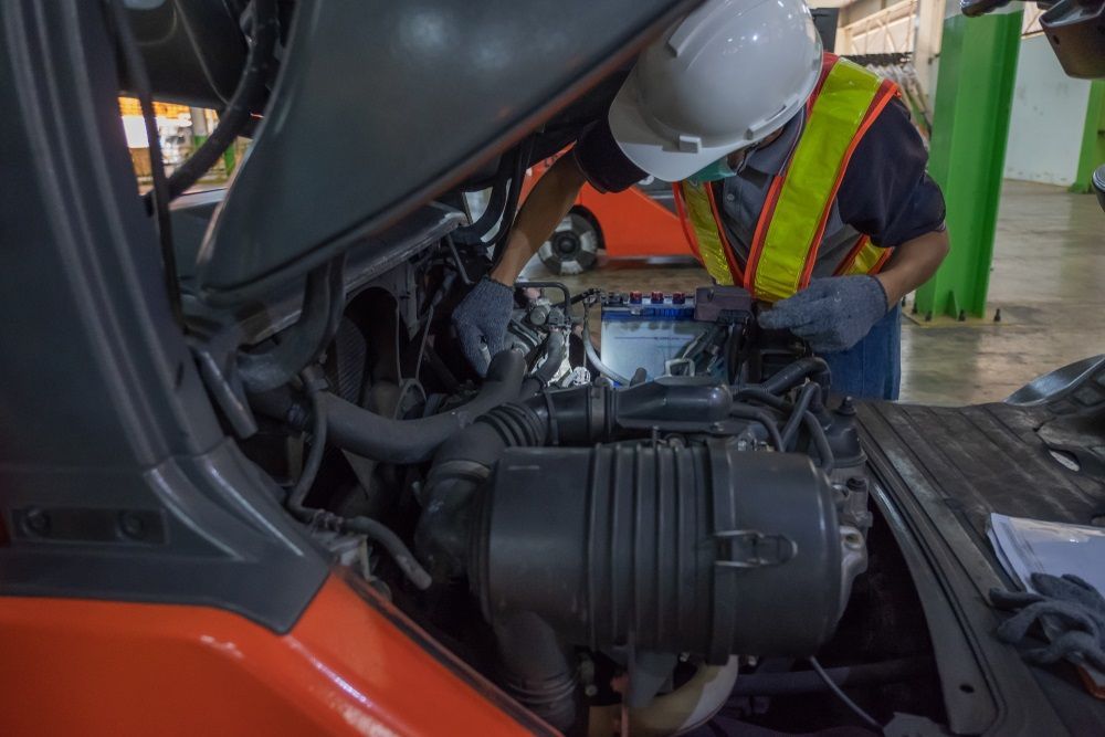 A Man is Working on the Engine of a Forklift — Rycam Automotive in Buderim, QLD