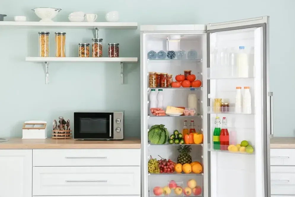 A Kitchen With an Open Refrigerator Filled With Fruits and Vegetables — Hire All in Tugun, QLD