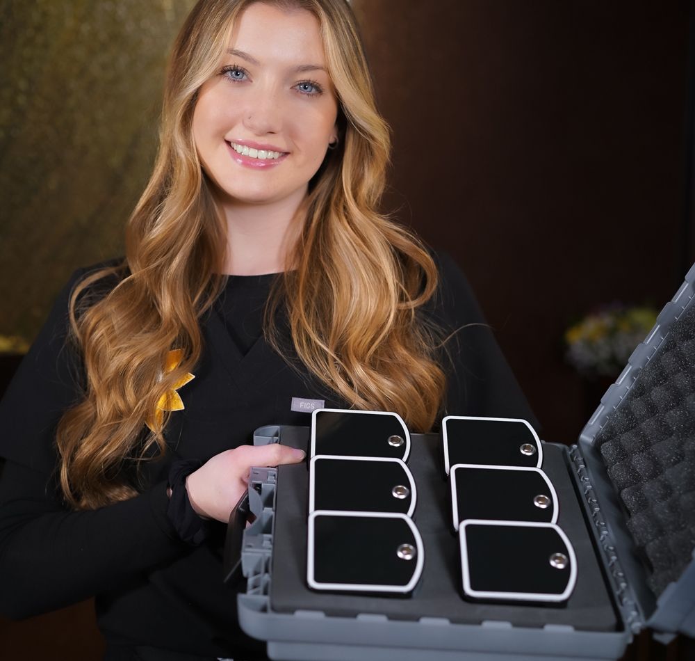 A woman in a black shirt is holding a case with the letter b on it