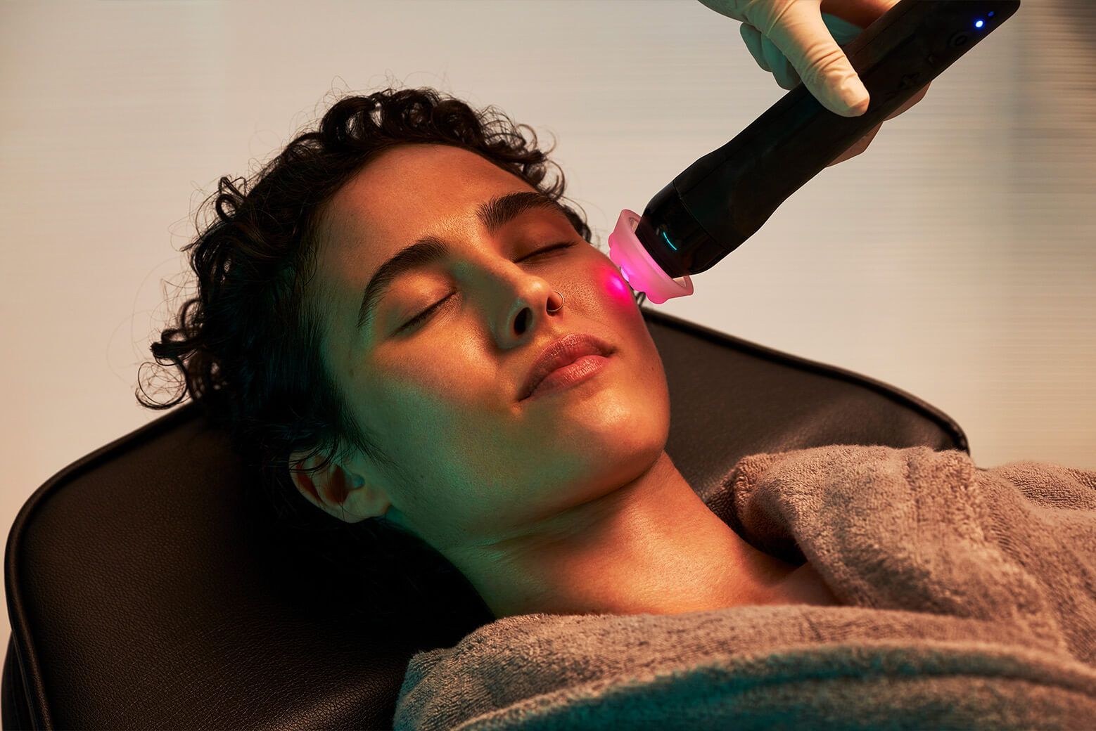 A woman is getting a laser treatment on her face.