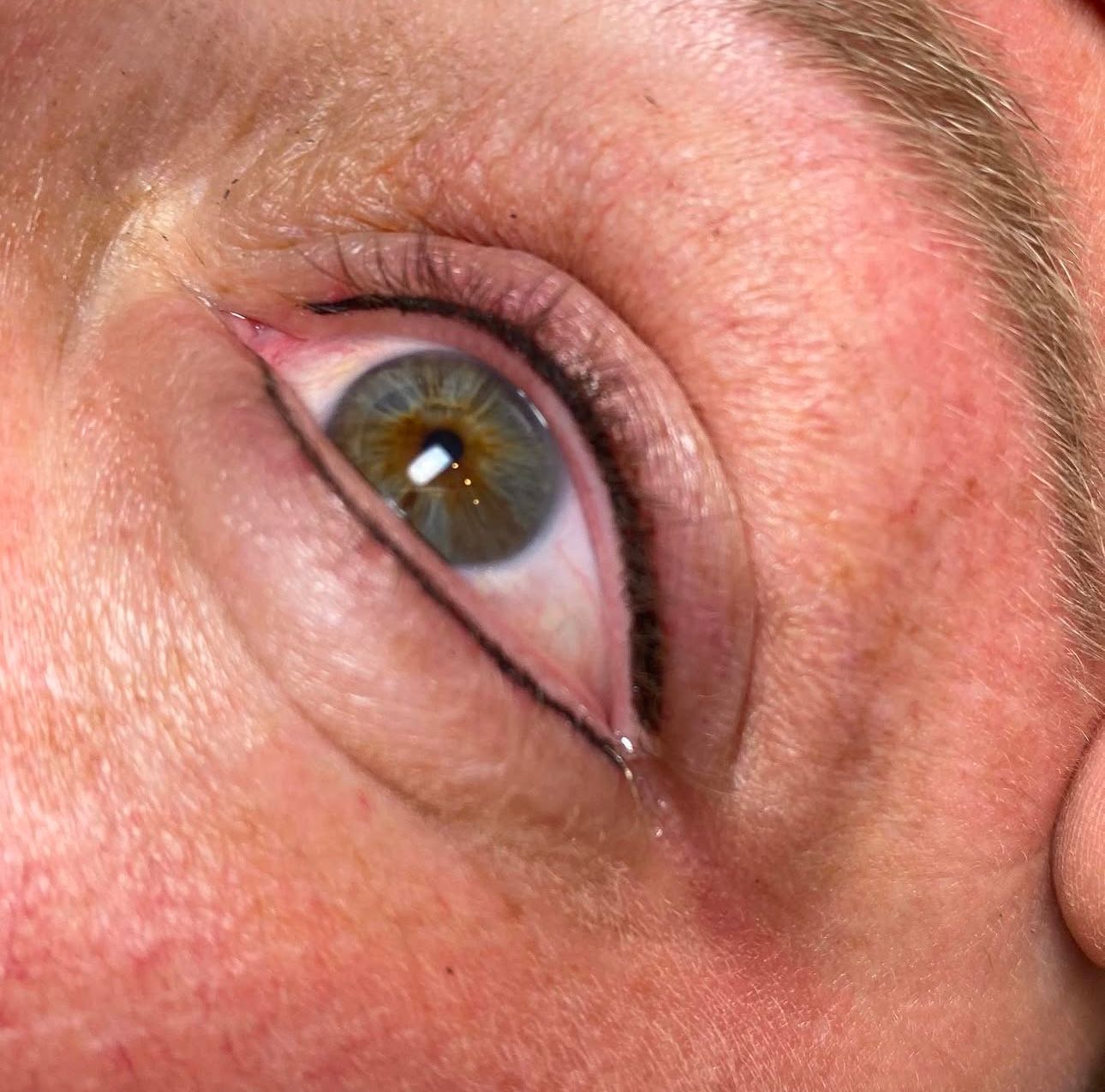 A close up of a person 's eye with eyeliner on it.