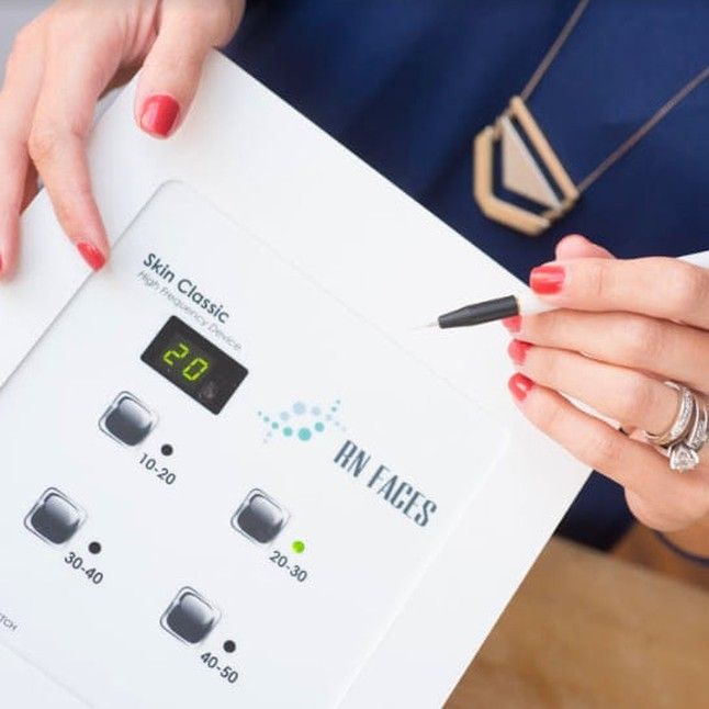 A woman is holding a device that says skin classic on it