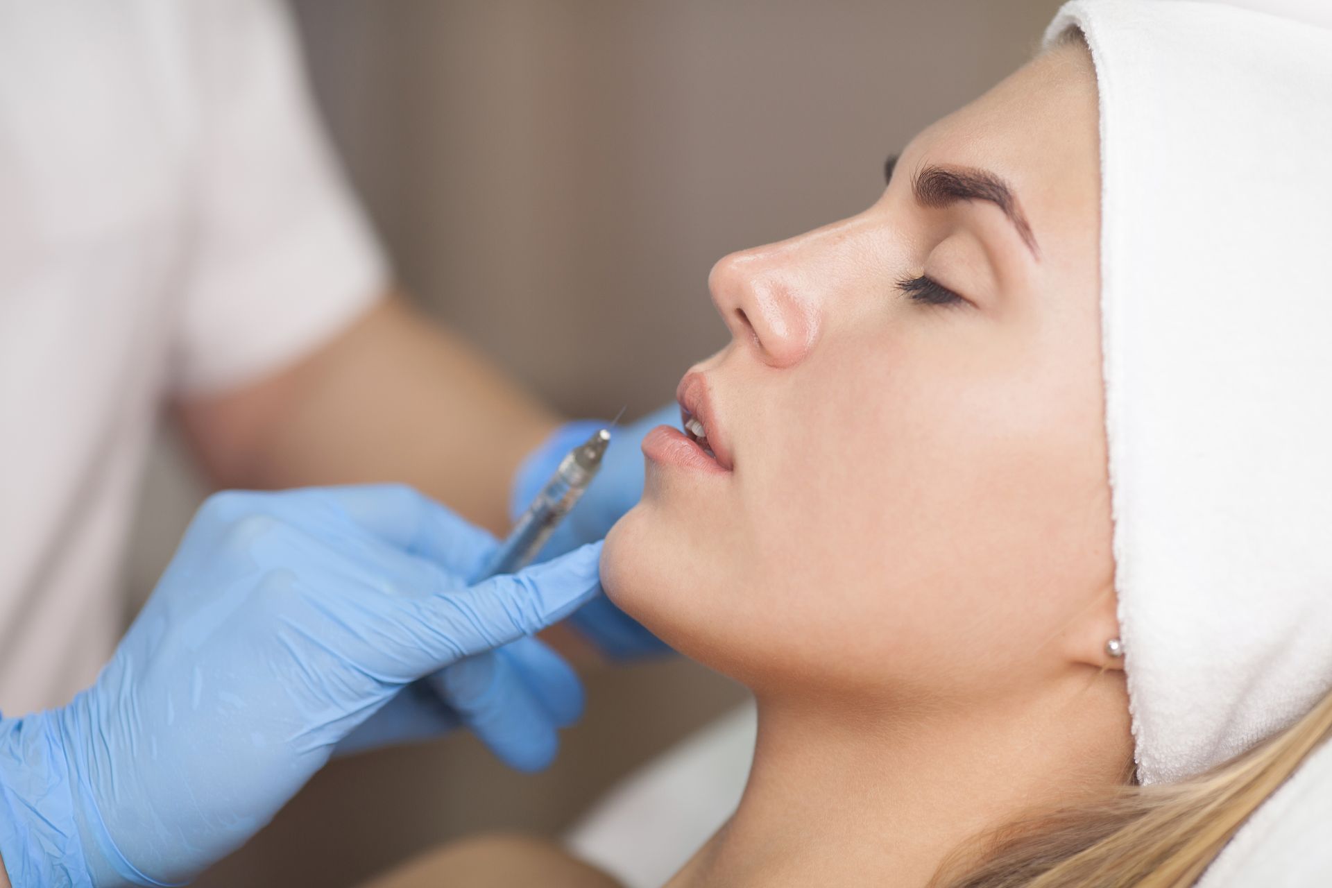 A woman is getting a botox injection in her lips.