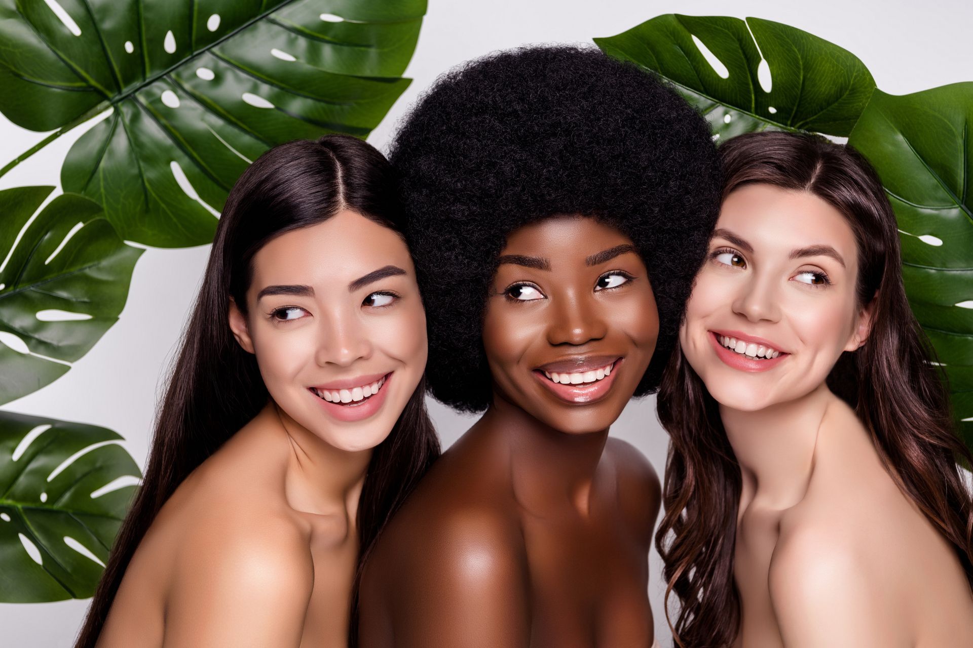 Three women of different races are posing for a picture together.