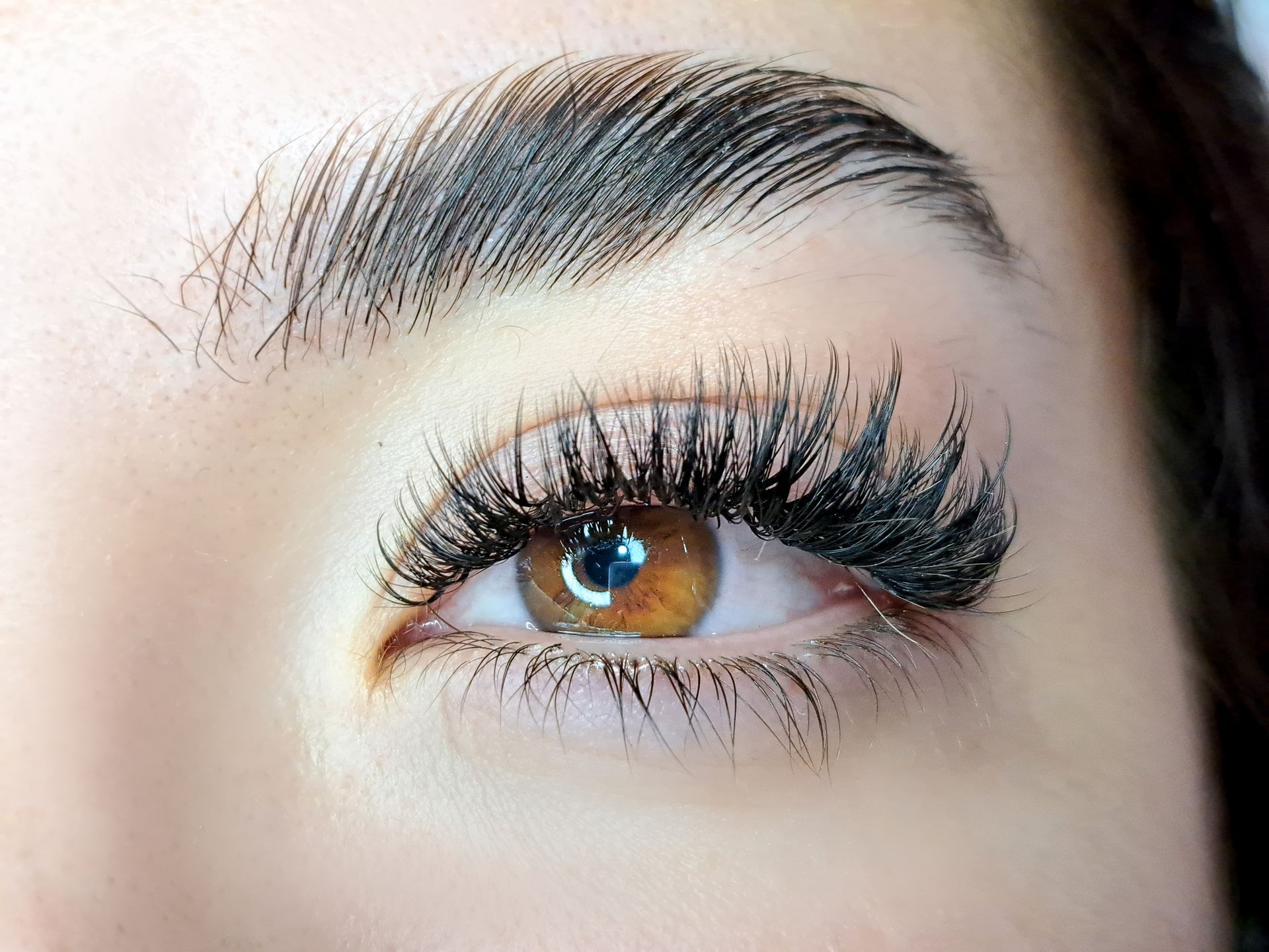 A close up of a woman 's eye with long eyelashes.