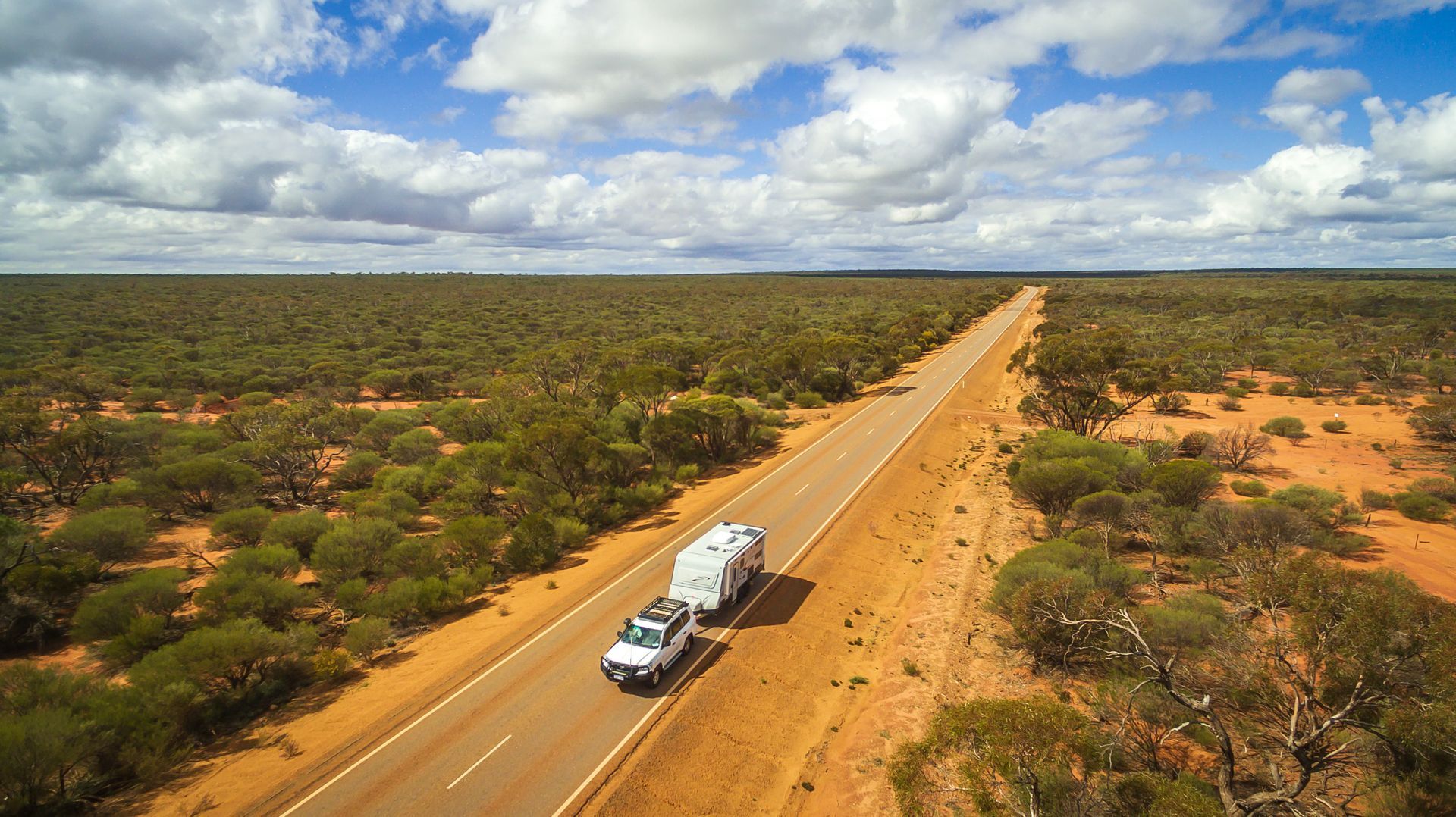 Two Trucks Drive on a Dusty Road Through a Dry — Dempsters Caravan & RV in Childers, QLD