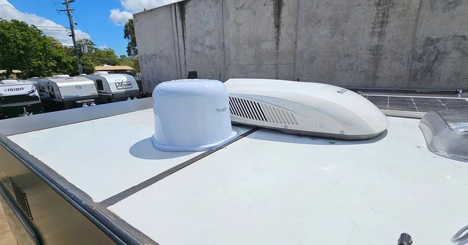 A White Air Conditioner is Mounted on the Roof of a Trailer — Dempsters Caravan & RV in Thabeban, QLD