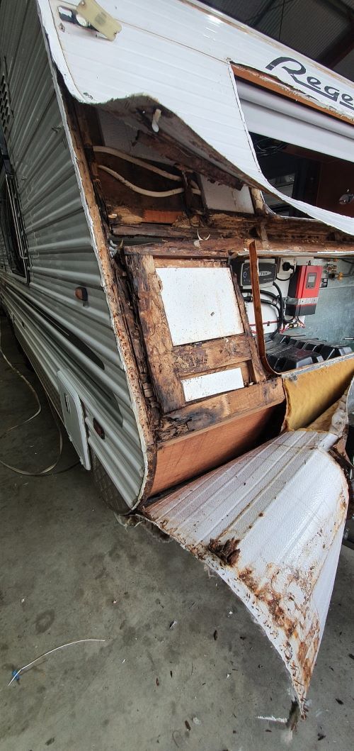 A Camper is Sitting on Its Side in a Garage — Dempsters Caravan & RV in Rockhampton, QLD