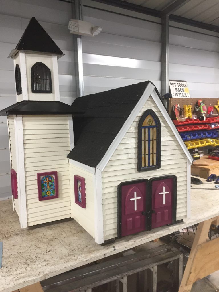 A small wooden church is sitting on top of a table.